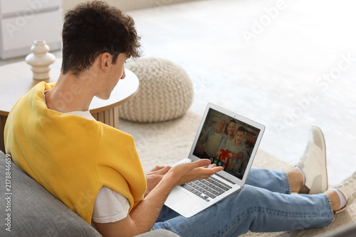 Young man video chatting with family at home