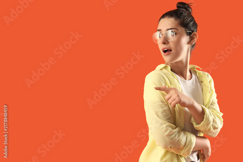 фотографія Young gossip woman pointing at something on orange background