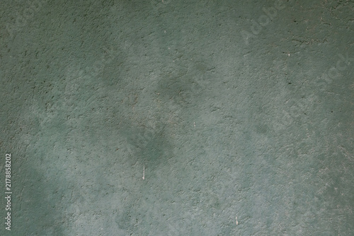 Full-frame abstract background texture of a dark green stucco plaster wall.