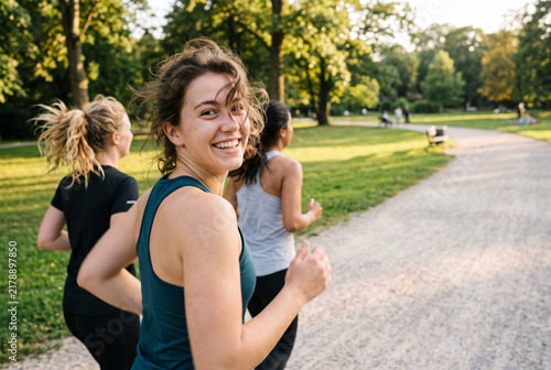 Joyful Young Women Running in Sunny Park, POV Close-Up Snapshot of Friends Jogging Together with Copy Space