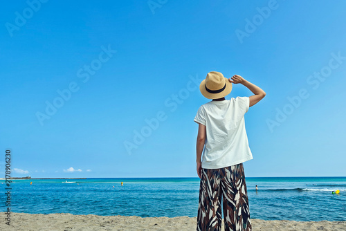 Tapety artystyczne 海を眺める麦わら帽子を被った女性後ろ姿