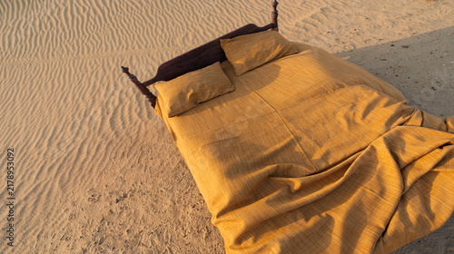 Bild auf Leinwand large double bed on the sand in the desert for background