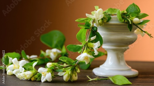 Sampaguita flower garland on ceramic pedestal dish with jasmine blossoms, fresh floral retail concept