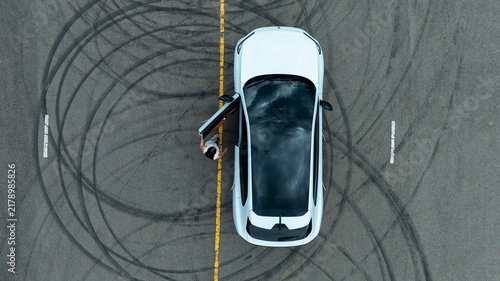 Woman stands near ev car.
She poses by white ev car.
Stylish ev car on road.