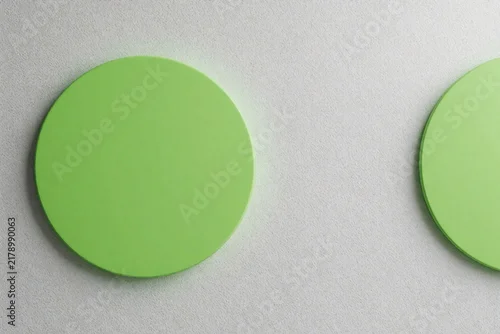 Panel kuchenny z motywem Abstract geometric pattern with lime green circles on light grey textured wall. Minimalist circular shapes create modern decor style. Round green elements form creative architectural background for