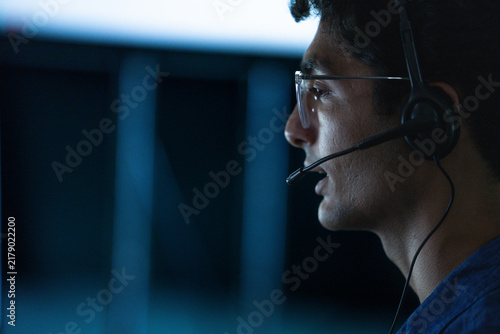 Quadro su tela A male support consultant gesturing while working through a ticket presses his h