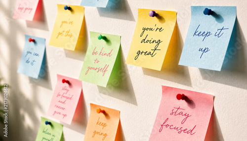 Quadro su tela Colorful motivational sticky notes pinned on light wall for inspiration