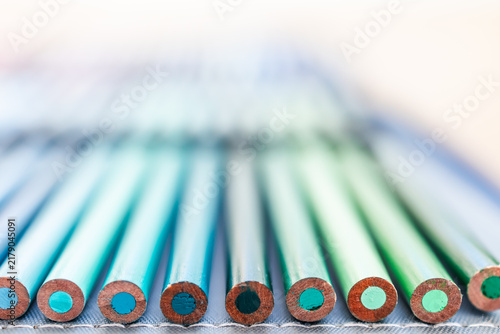 close-up of blue and green colored pencils neatly lined up in pencil case, concept of creativity and drawing