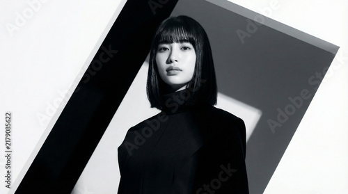 Plakat 幾何学的な背景の中に立つ黒い衣装のモードな日本人女性
