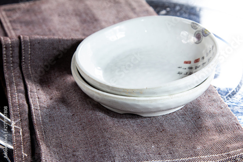 Foto Two small white dishes resting on a folded gray cloth