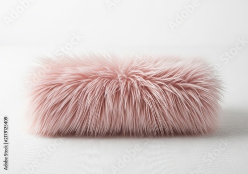 Rectangular bolster pillow covered in soft, long-pile dusty pink faux fur, isolated on a plain white background