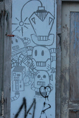 Graffiti Art on an Aged Wooden Door in an Antique Stone Building Entrance