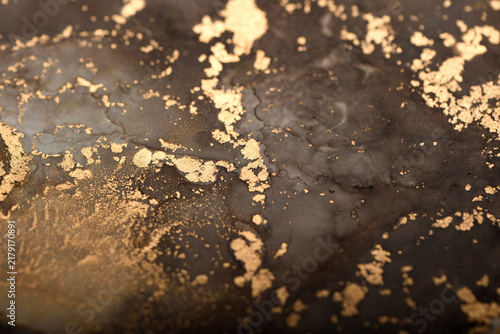 Artistic background with dark brown and gold swirls – close-up photo