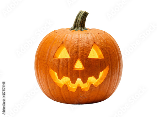 Фотография Glowing carved orange pumpkin jack-o-lantern with a spooky smiling face and gree