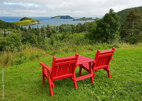 Fotografie two red adirondack chairs in a scenic overlook in summer at tors cove , overlook