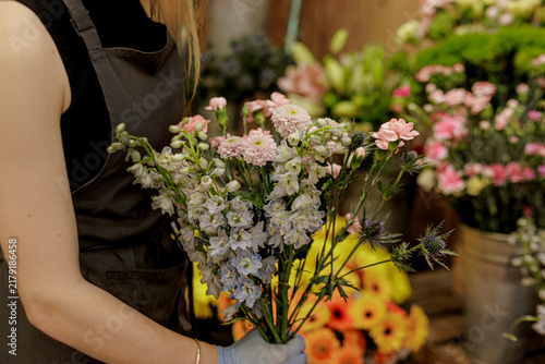 Obraz na plátne Florist with larkspur, carnations in flower shop Mothers day