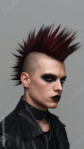 Edgy punk man with a dramatic spiked mohawk  dark makeup  shaved sides  leather clothing  and a rebellious alternative fashion style.