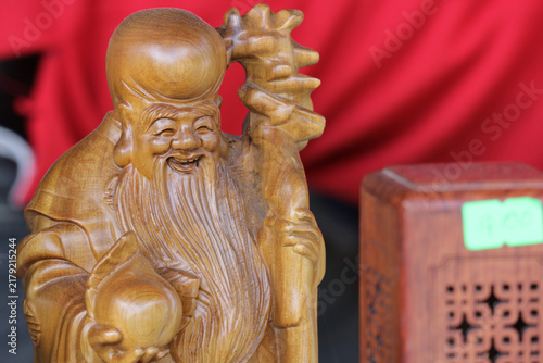 Canvastavla Shou Lao wood carving statue of longevity god on red background, hand carved woo
