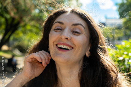 Obraz na płótnie Close up headshot of happy laughing 38 year old Armenian woman outdoors