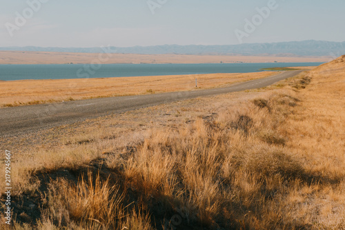 Cuadro en lienzo Long empty asphalt road running alongside river Irtysh shore through dry steppe hills in East Kazakhstan