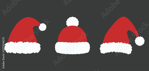 Set of three different red santa claus hats with white fur trim a dark background