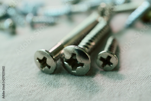 Konstfotografi Three Phillips Screws Resting on a Fabric Surface