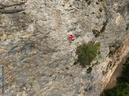 Canvas Print Aerial shot shows a climber on a massive rock face