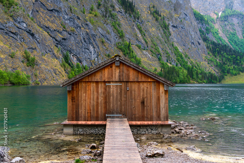 Bild auf Leinwand Traditional wooden boathouse on the turquoise shore of Lake Obersee in Bavaria,