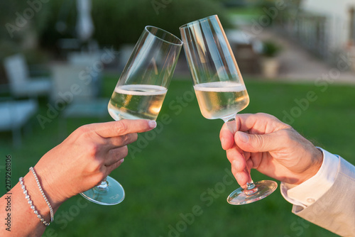 Brindisi di coppia con calici di vino frizzante all'aperto durante un evento