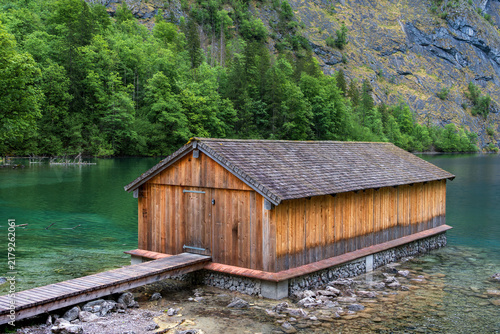 Bild auf Leinwand Traditional wooden boathouse on the turquoise shore of Lake Obersee in Bavaria,