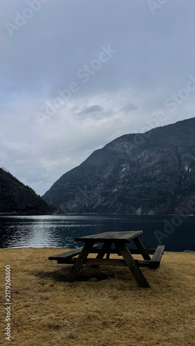 Quadro su tela Scenic Norwegian fjord with mountains and wooden picnic table
