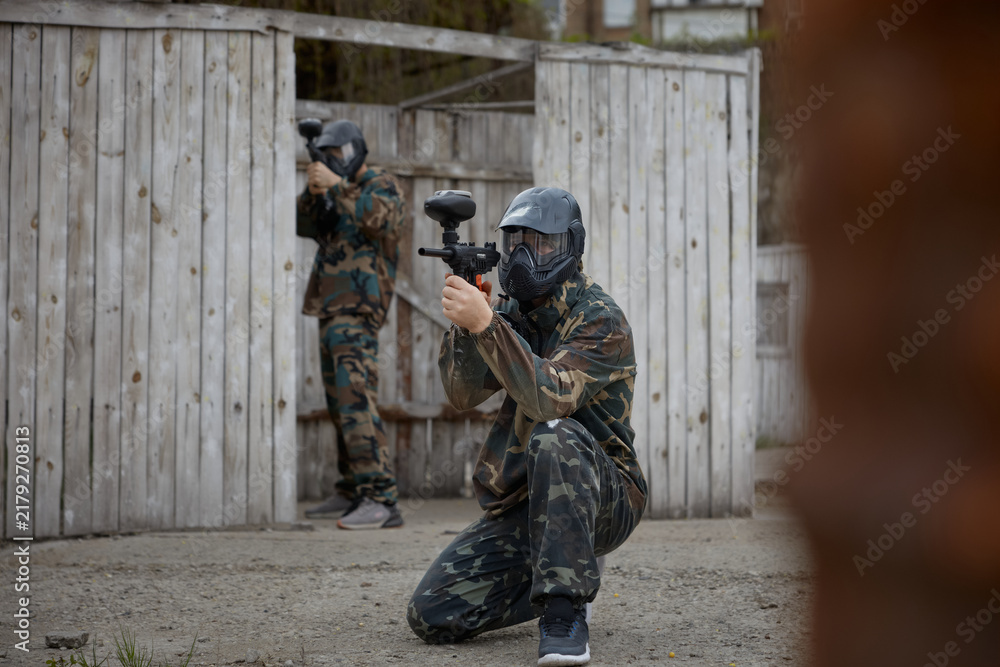Obraz premium Soldiers are taking positions during tactical weapon training, one aims while sitting on the ground