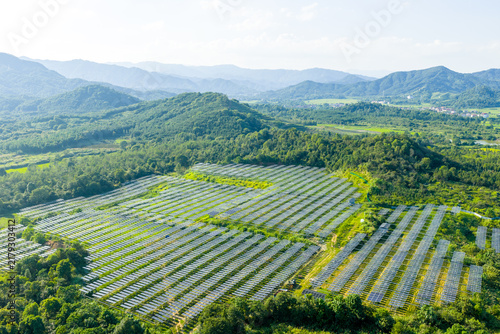 Neat solar photovoltaic panels arranged in green mountains