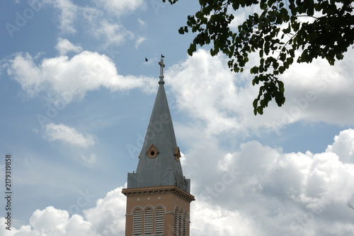 Photography Rooster Church steeple with weathercock and cross against blue sky in Da Lat, Vi