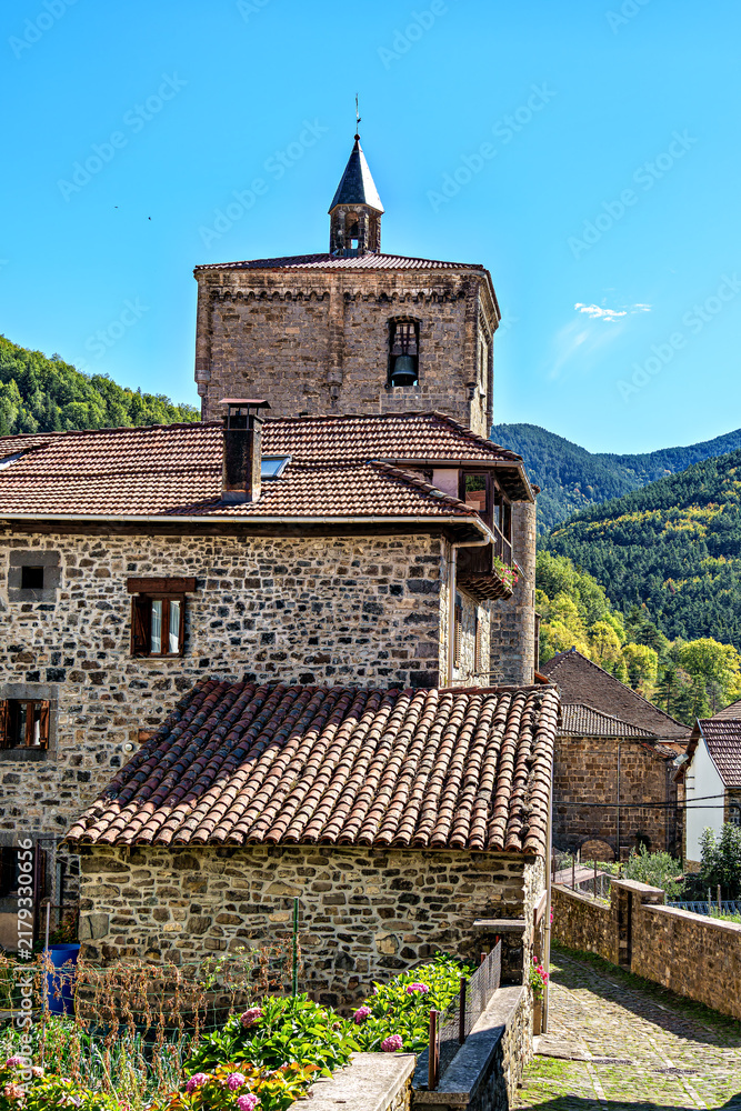 Obraz premium Strolling through Isaba in Roncal valley, Pyrenees, Navarre in Spain with brownish tiled roofs of residential buildings