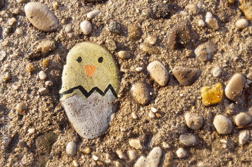 A chicken hatched from an egg stone, Easter background