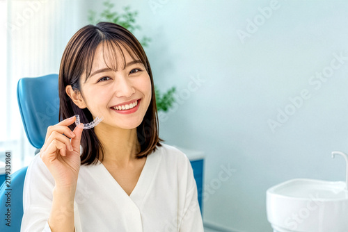 Obraz w ramie 歯科医院でマウスピース矯正装置を手に笑顔の女性、コピースペース