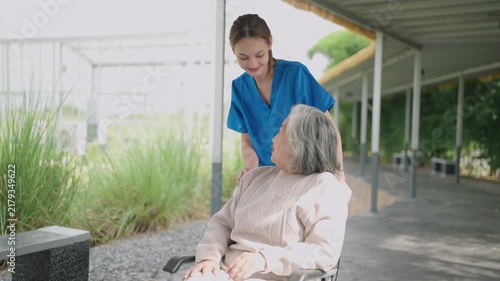 Caregiver help and care Asian senior or elderly old lady woman patient sitting in wheelchair on ramp at nursing hospital, healthy strong medical concept