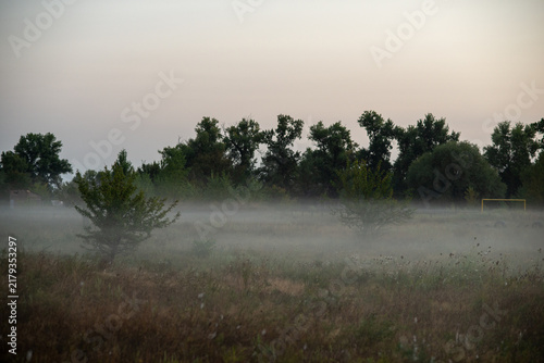 Foto Masked figure with knife in surreal autumn Halloween mist