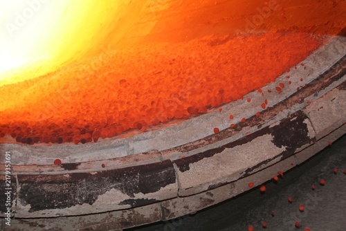 Foto Industrial hot pyrometallurgical rotary kiln discharging red hot ore pellets