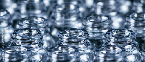 Rows of empty transparent glass bottles in closeup