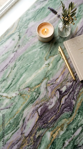 Luxury green and purple marble background with gold veins, burning candle, notebook, pen and flowers. Minimal aesthetic template with copy space for wellness, beauty and creative workspace design.