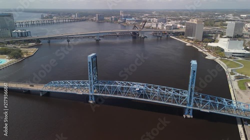 Aerial view of Jacksonville's Main Street Bridge over the St. Johns River with downtown buildings, waterfront parks, and multiple river crossings