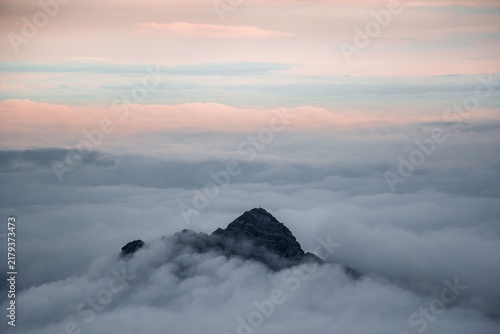 Cuadro en lienzo A serene mountain peak emerges gracefully above a thick blanket of rolling cloud