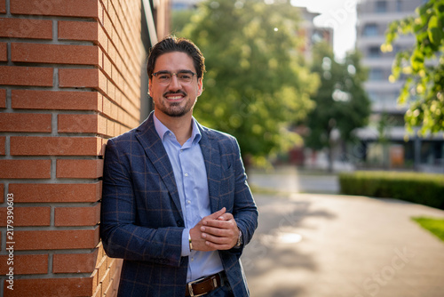 Obraz na plátne Confident young businessman smiling in urban setting