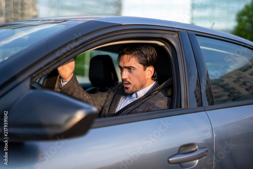 Obraz na płótnie Concerned man driving car reacting to traffic situation