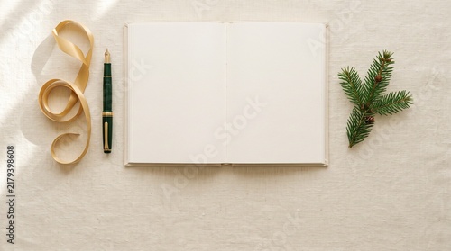 Christmas flat lay with a blank notebook and gold ribbon