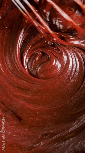 melted chocolate being whisked in swirling spiral texture, close-up- vertical video