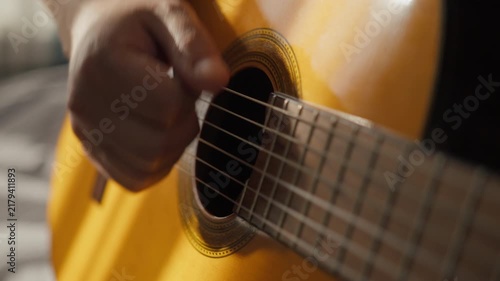 Playing acoustic guitar. Musician Playing On Guitar. Close-up On Moving Hand On strings. Man Strumming On Strings By Hand On Acoustic Guitar In Sunlight. Guitar play learning and practice