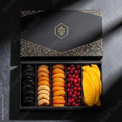 Luxury gift box with assorted dried fruits and berries on dark background